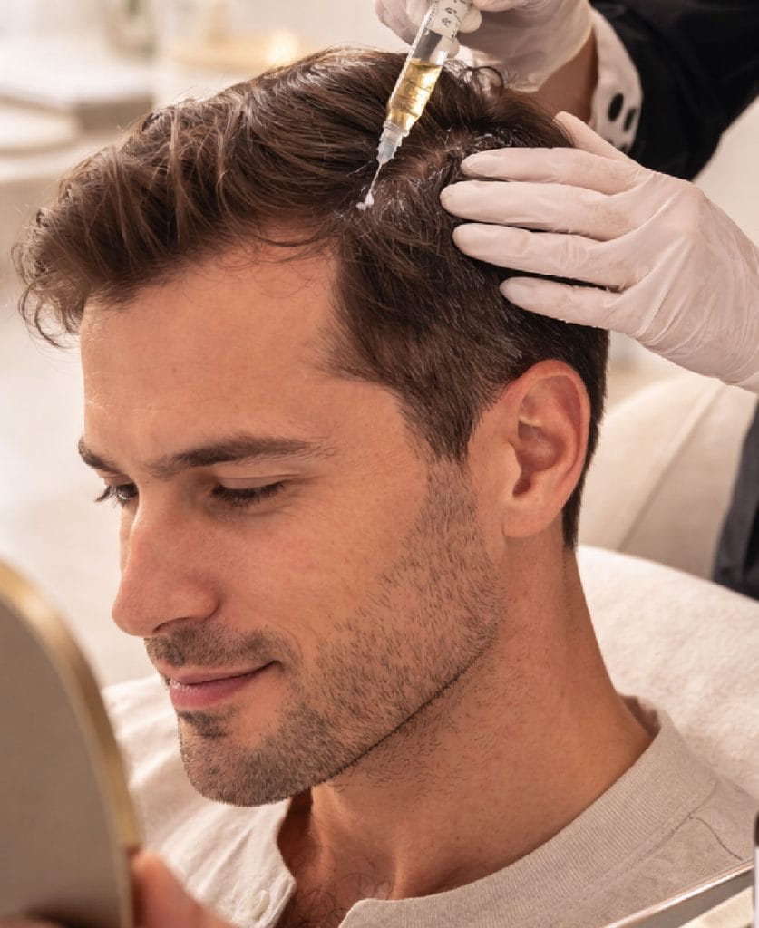 Aplicación de tratamiento médico anticaída en hombre en Clínica Etérea Valencia bajo supervisión especializada.
